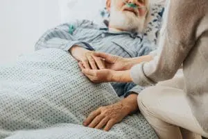 patient and caregiver holding hands