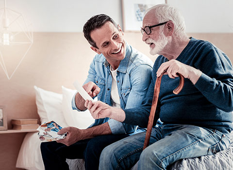 Young man shows senior man a photograph
